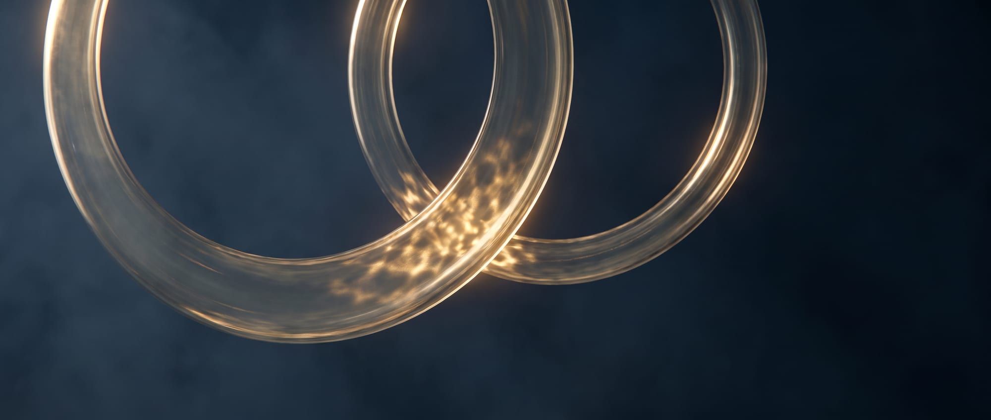 Two golden glass rings overlapping on deep navy